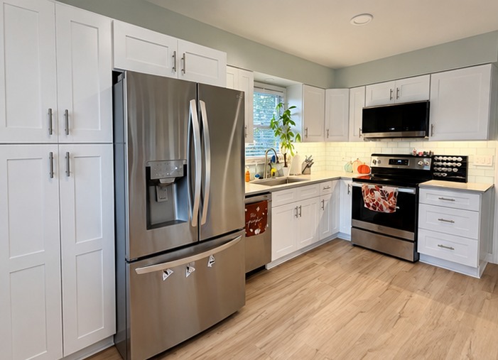 Wide view of White Shaker cabinets, Gray Galaxy quartz countertops, and tile backsplash in a Belton, MO kitchen