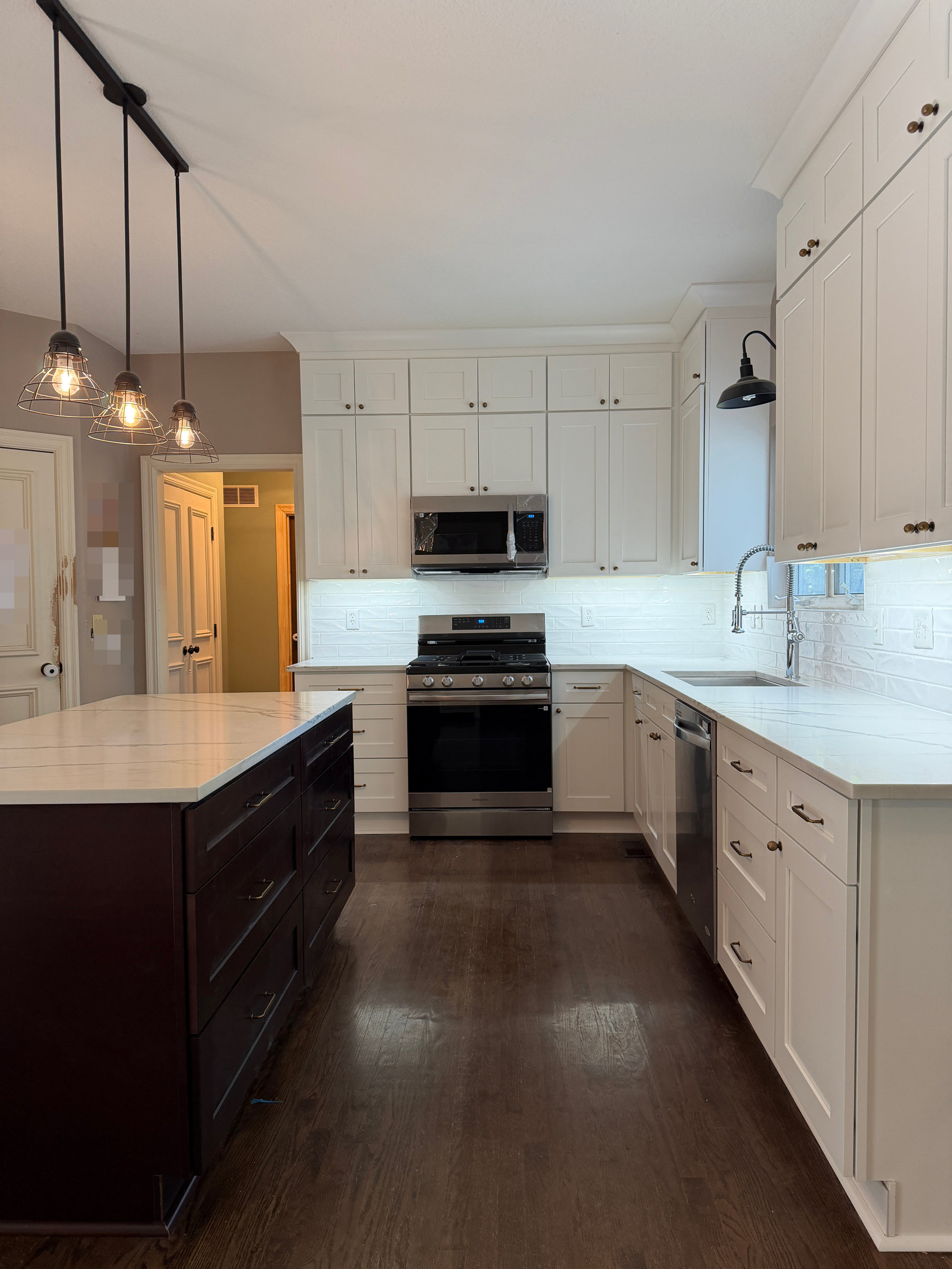 Dove White stacked shaker cabinets, refreshed quartz countertops and ebony island in a Leawood, KS kitchen renovation